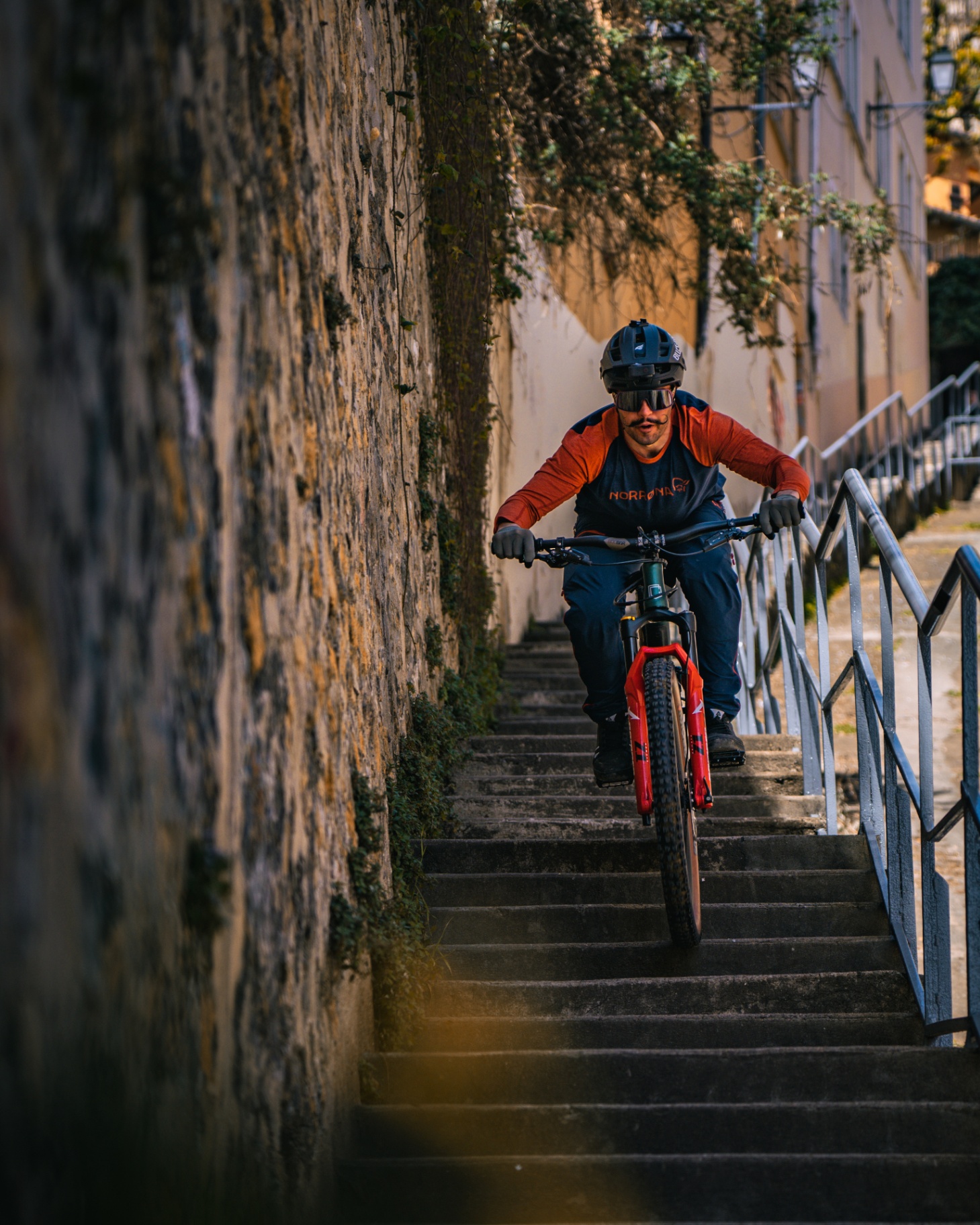 Rider VTT descendant des escaliers dans une ruelle ocre du Vieux Lyon
