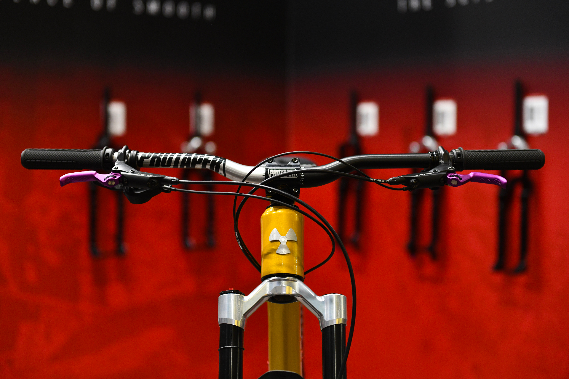 Cockpit Nukeproof or, cintre ProTaper et fourche, fond rouge stand salon