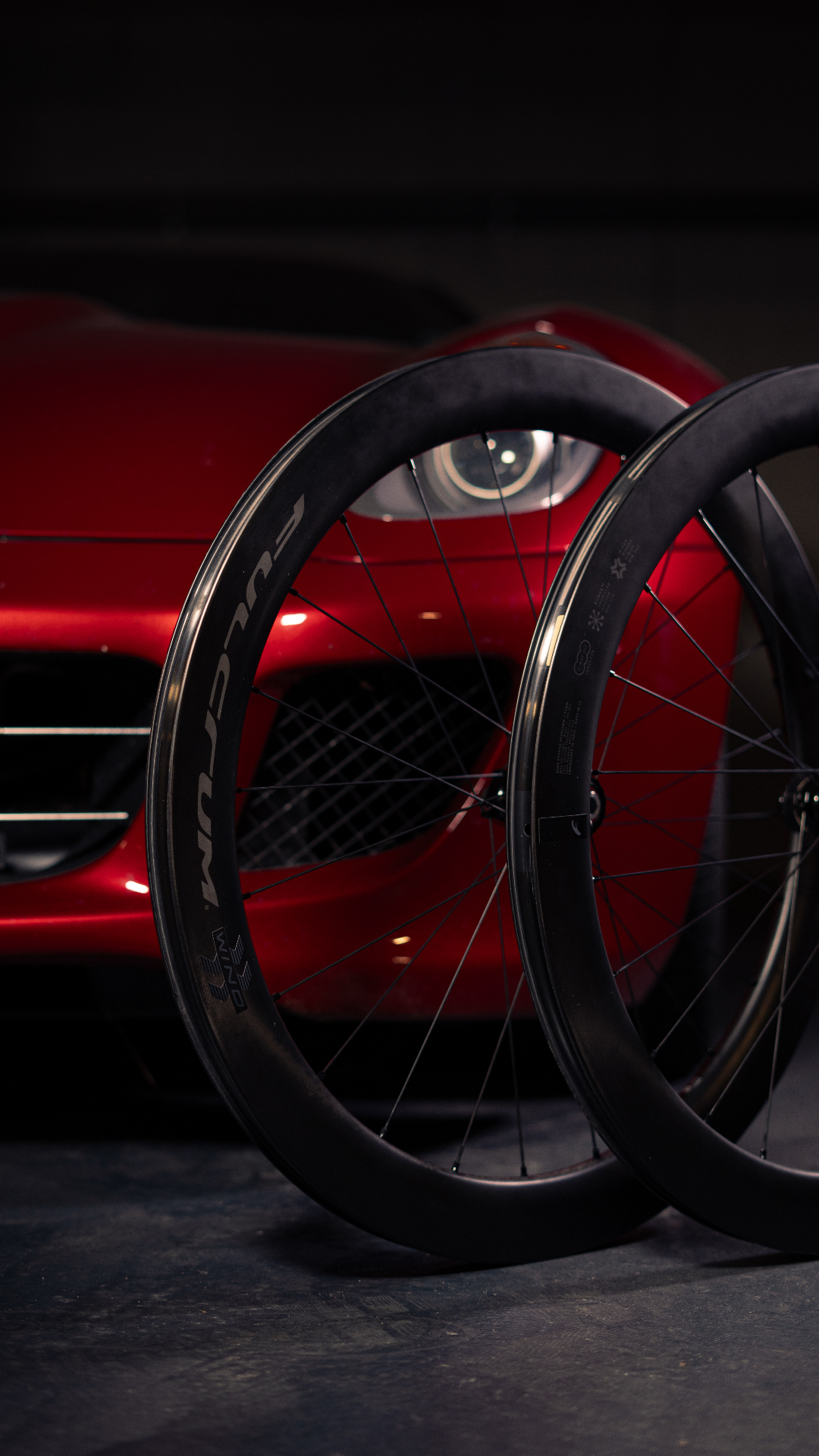 Roues carbone Fulcrum Wind devant une voiture de sport rouge