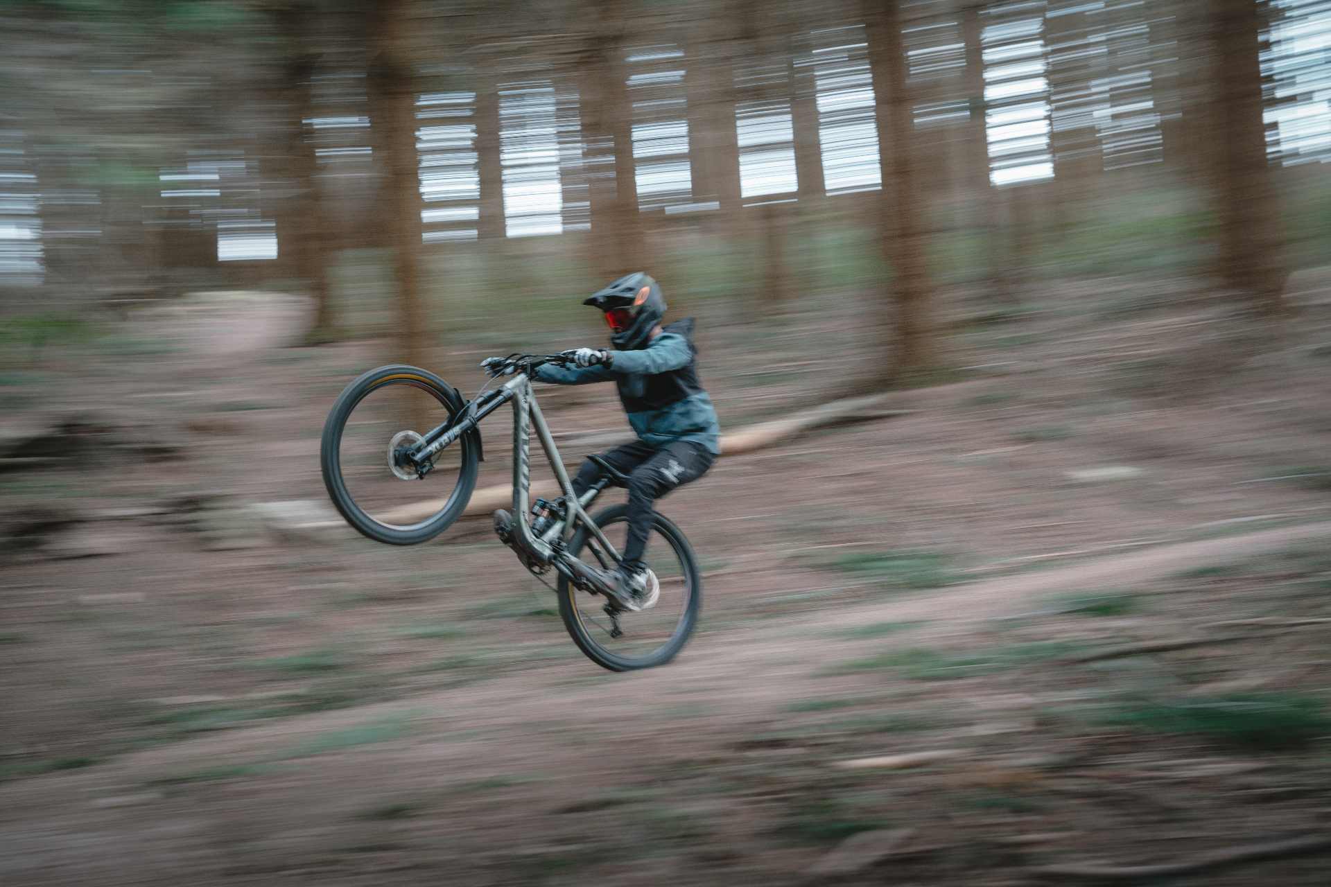 Rider VTT en wheelie, panning dans une forêt — direction artistique action